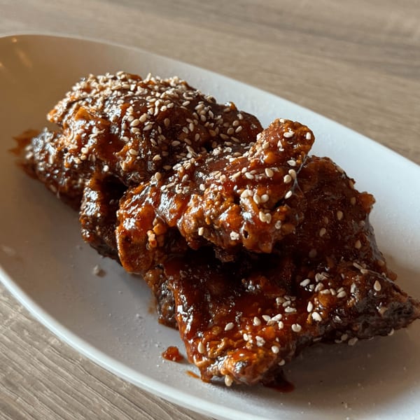 Yatai Ramen's Japanese fried chicken wings, glazed in a dark sauce and sprinkled with sesame seeds.