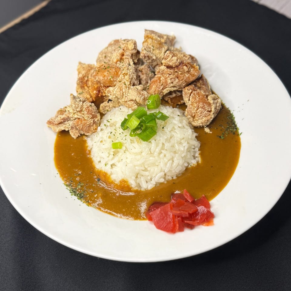Japanese chicken karaage with curry sauce, white rice, green onions, and red pickled ginger.